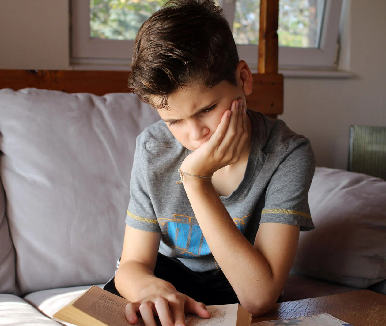 A dyslexic student struggles to read a book