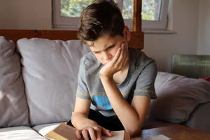 A dyslexic student struggles to read a book