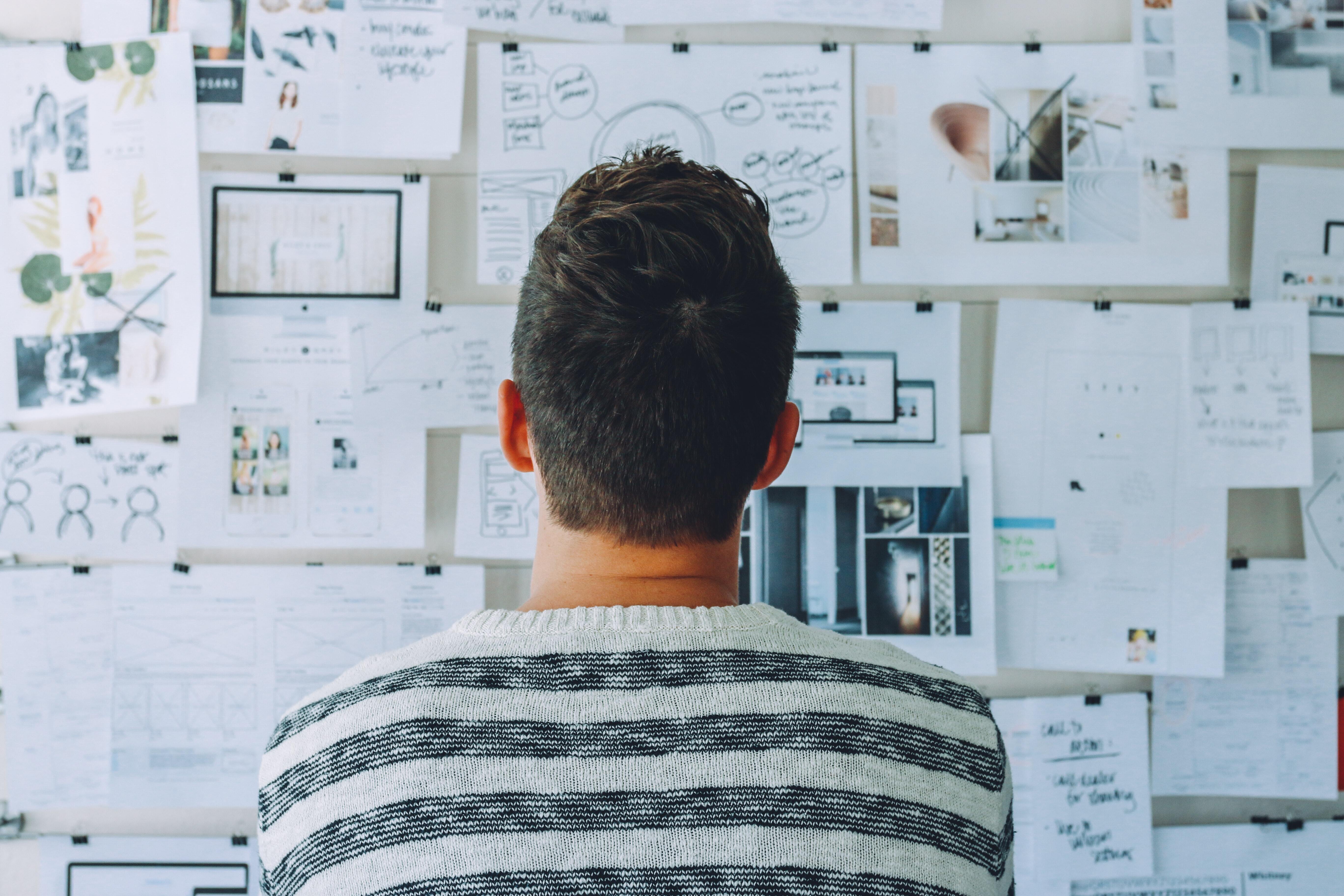 man wearing a striped shirt looking at a whiteboard