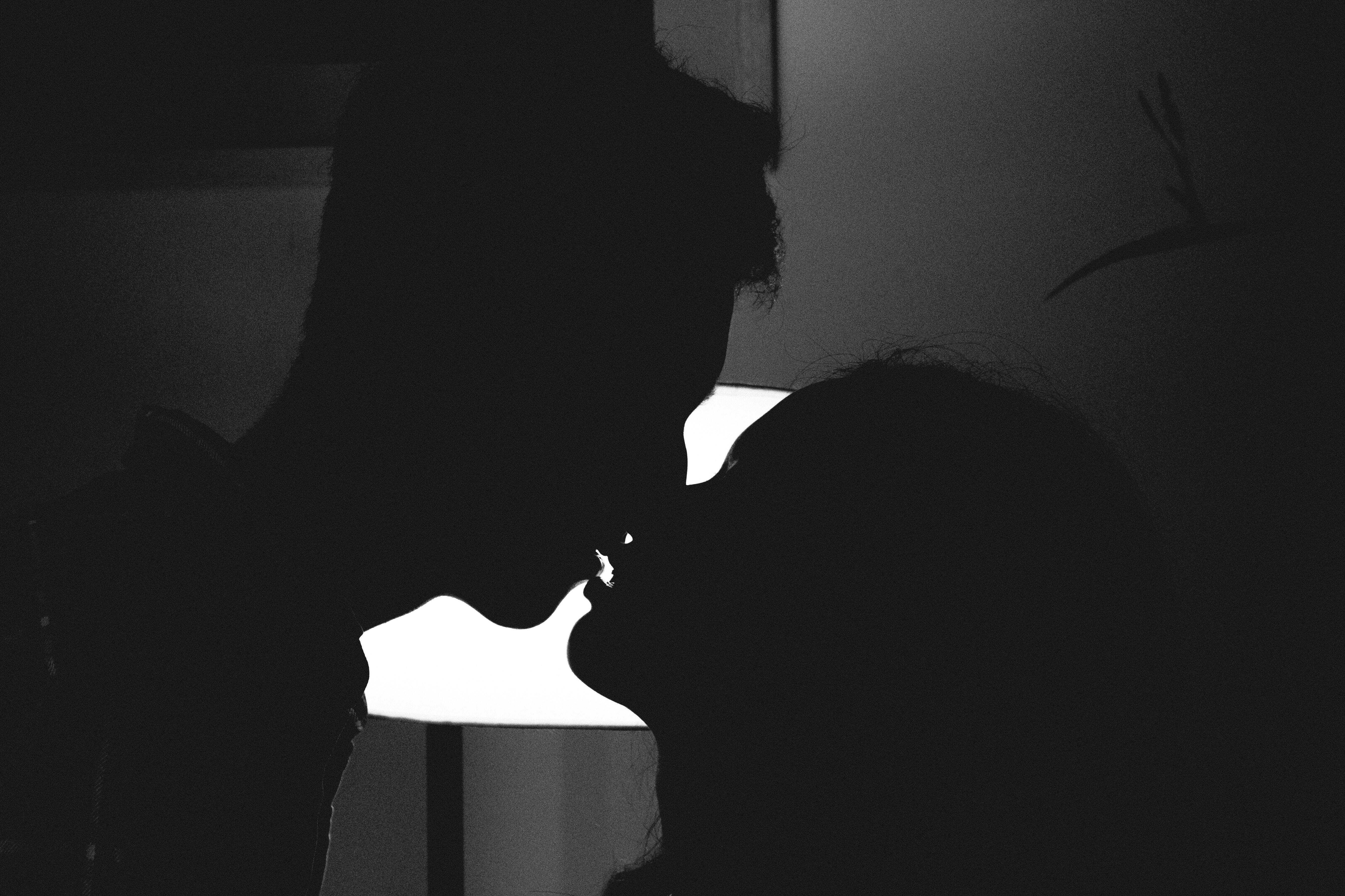 Silhouette photo of a man and woman kissing.