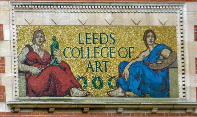 A photograph of the Leeds College of Art mosaic. Mosaic against a brick wall. Central panel reads 'Leeds College of Art' flanked by allegorical figures: Sculpture on the left, Painting on the right.