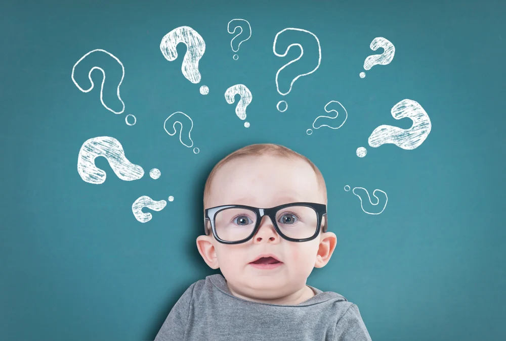 A funny image of a toddler wearing adult-style glasses rests against a background covered with question marks.