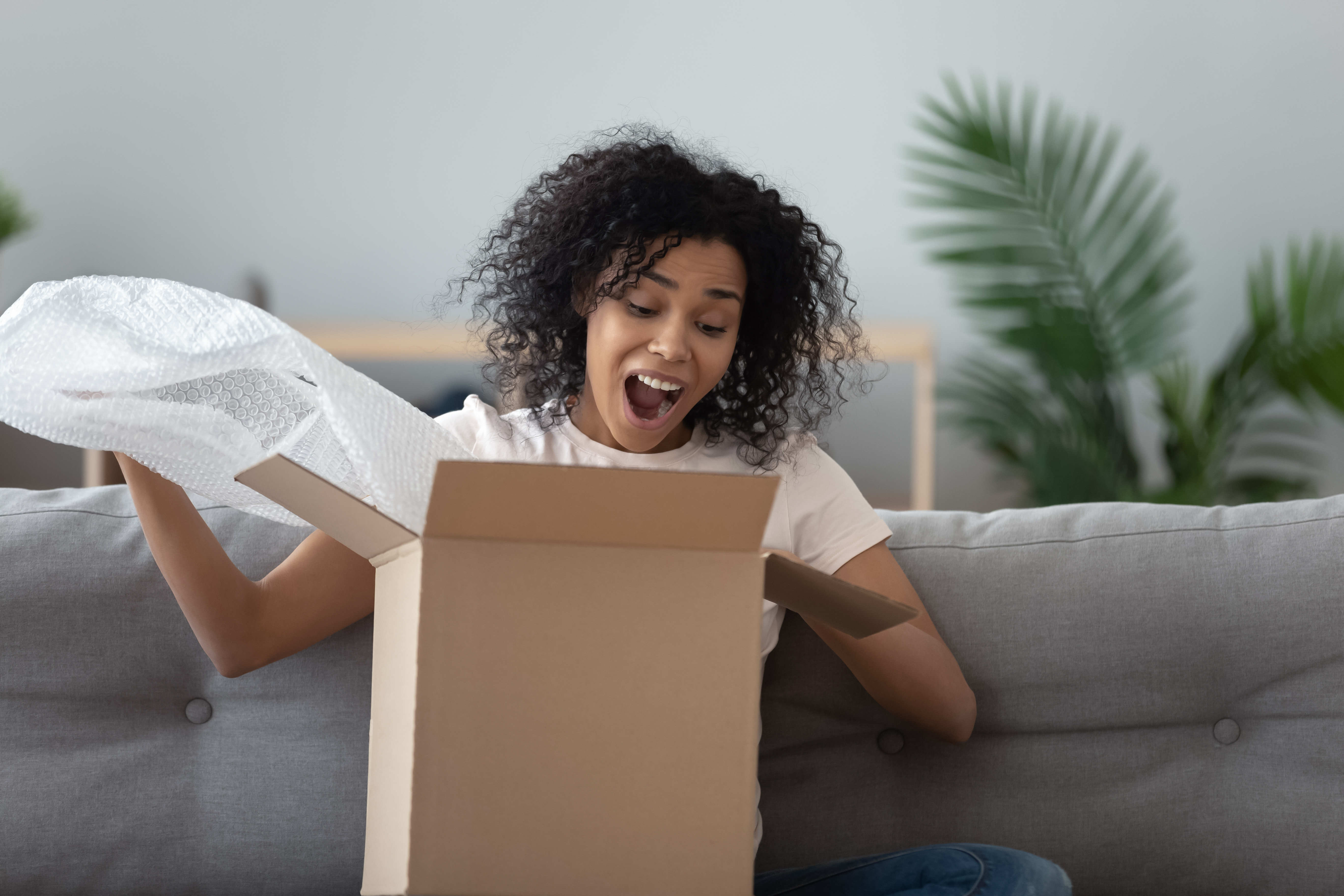 Excited woman unpacking large cardboard box