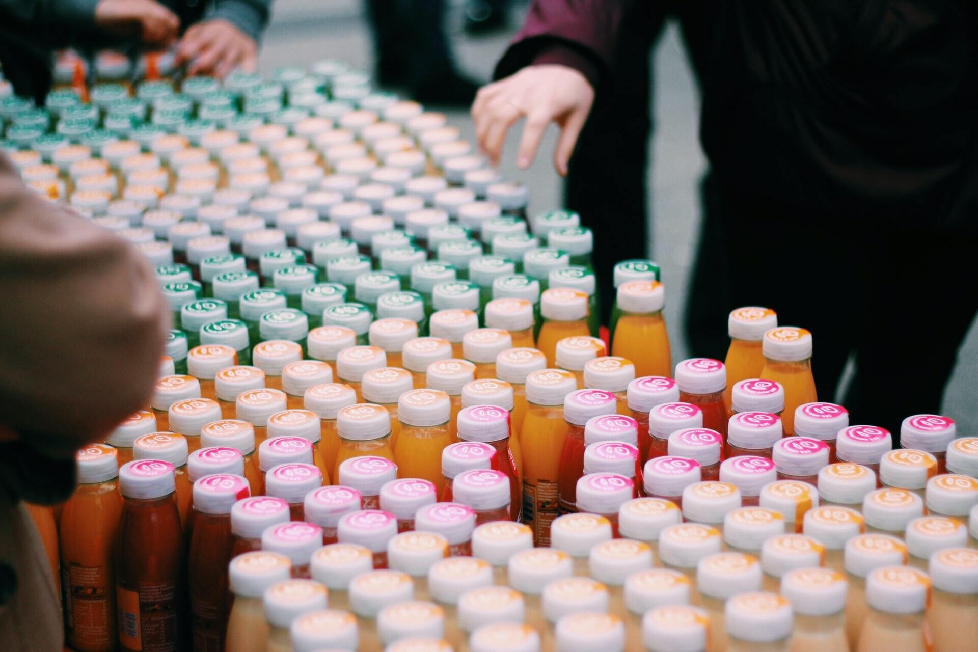 Photograph of an assortment of juice bottles taken from a high angle so you can just see the tops with different coloured labels.