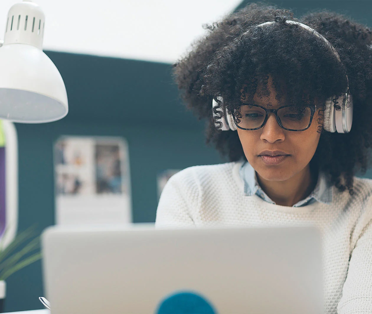 lady at a laptop, wearing headphones