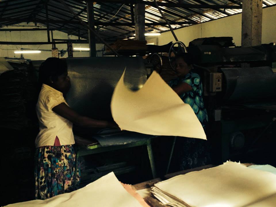 Woman with sheets of handmade paper