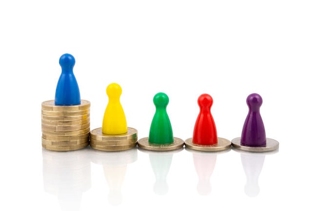 Image of coins stacked up at different levels, representing inequality between classes.