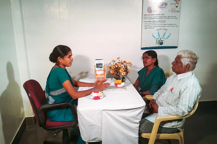 Health worker talking with patient and family