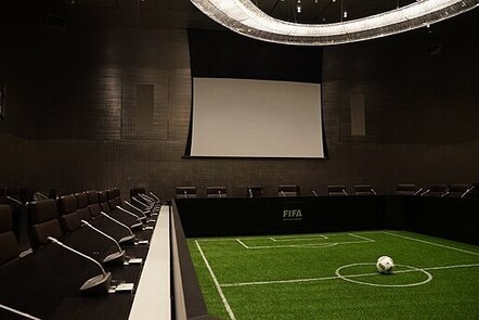 A miniature football field surrounded by a boardroom