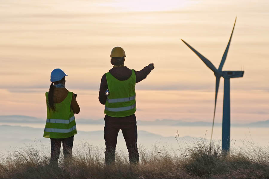 Alternative energy concepts. Maintenance engineers supervising the condition of the power equipment in a wind turbines power station with digital tablet. Sustainability bonds and guidelines.