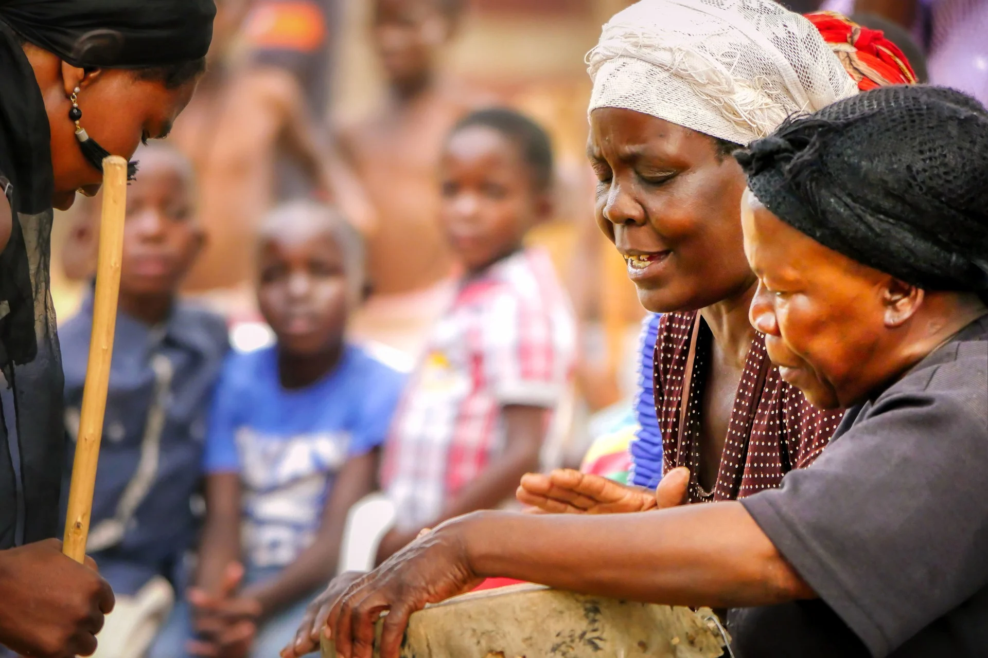 Two Zimbabwean women playing a drum.