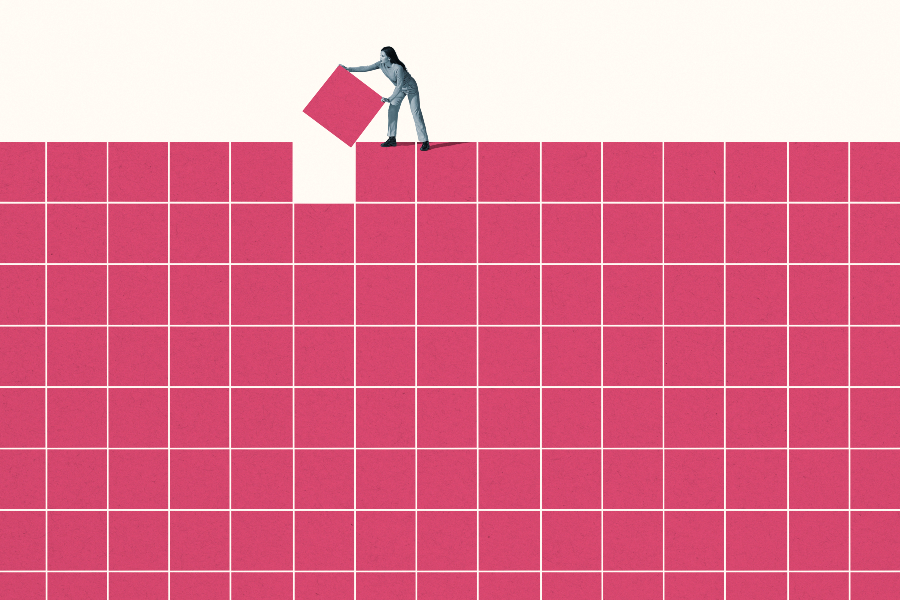 A person standing on top of rows of squares, they are slotting the one remaining square into the one remaining gap.