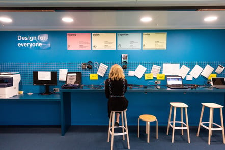 a person using the GDS accessibility lab, sitting at a desk, surrounded by a range of devices 