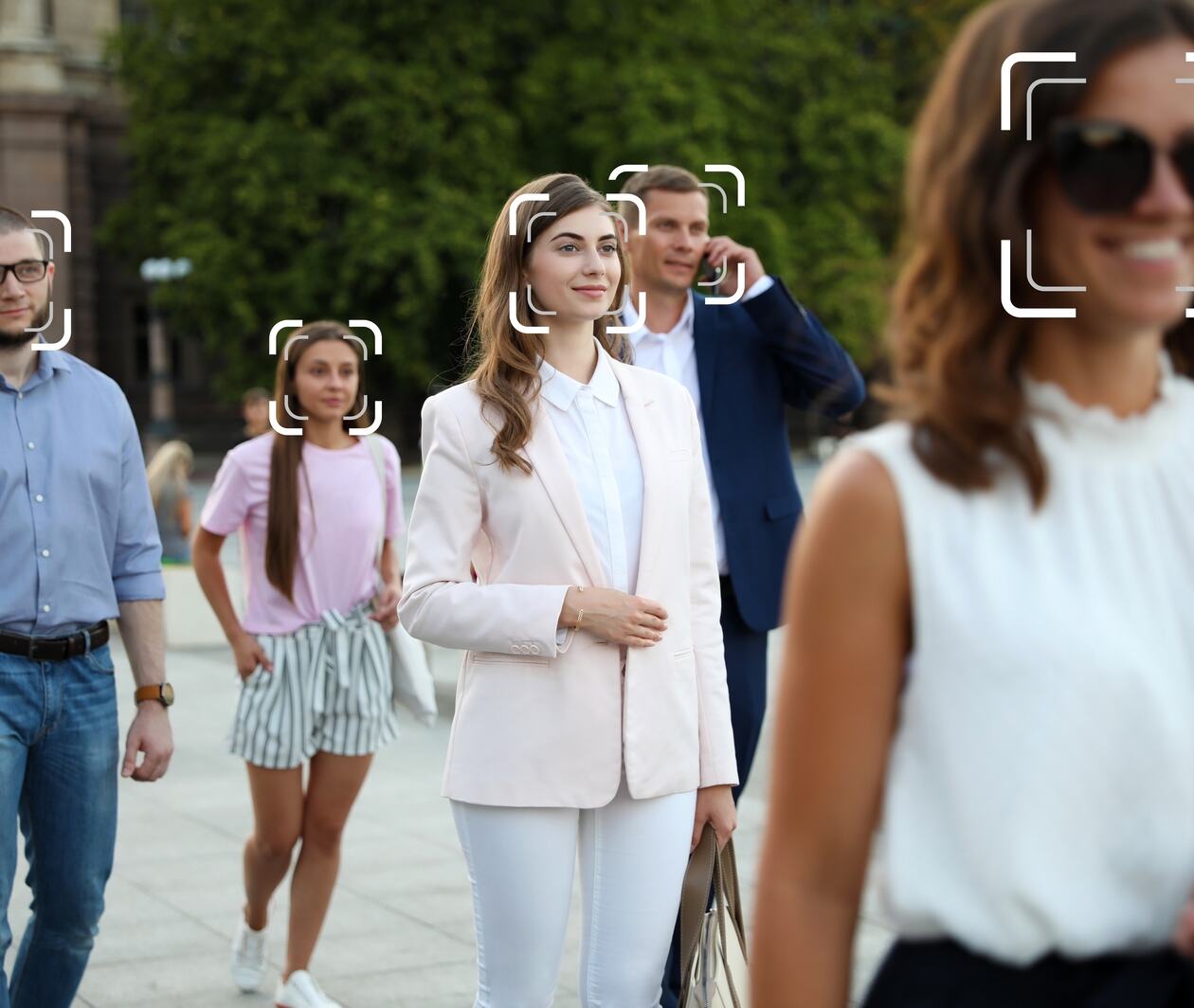Facial recognition system identifying people on city street, selective focus