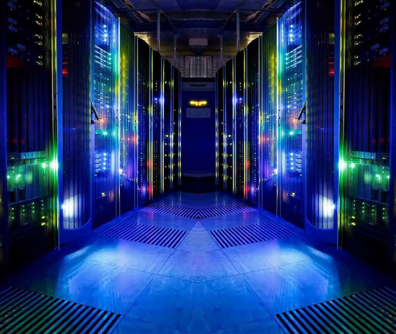 A room with computer server racks with lots of small flashing lights