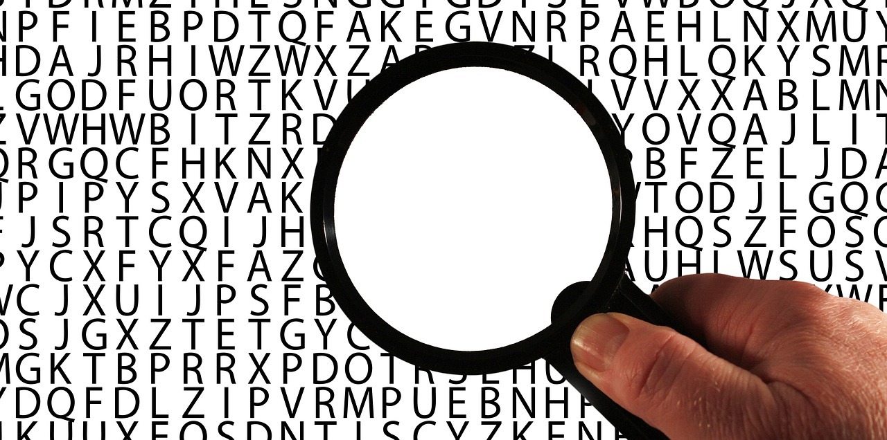 Magnifying glass over lots of letters