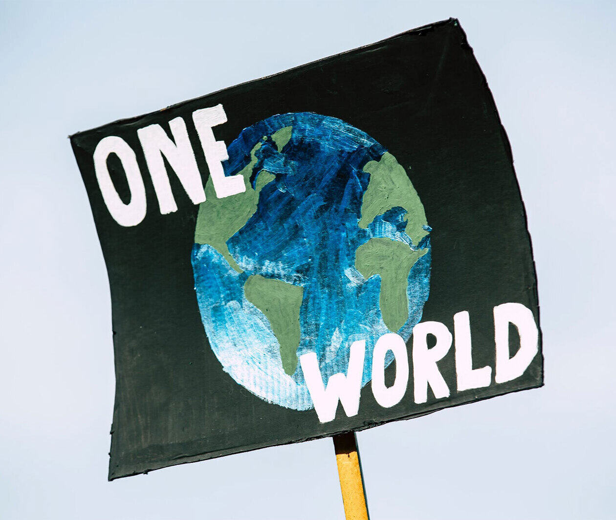 Placard showing the earth and the words 'one world'.