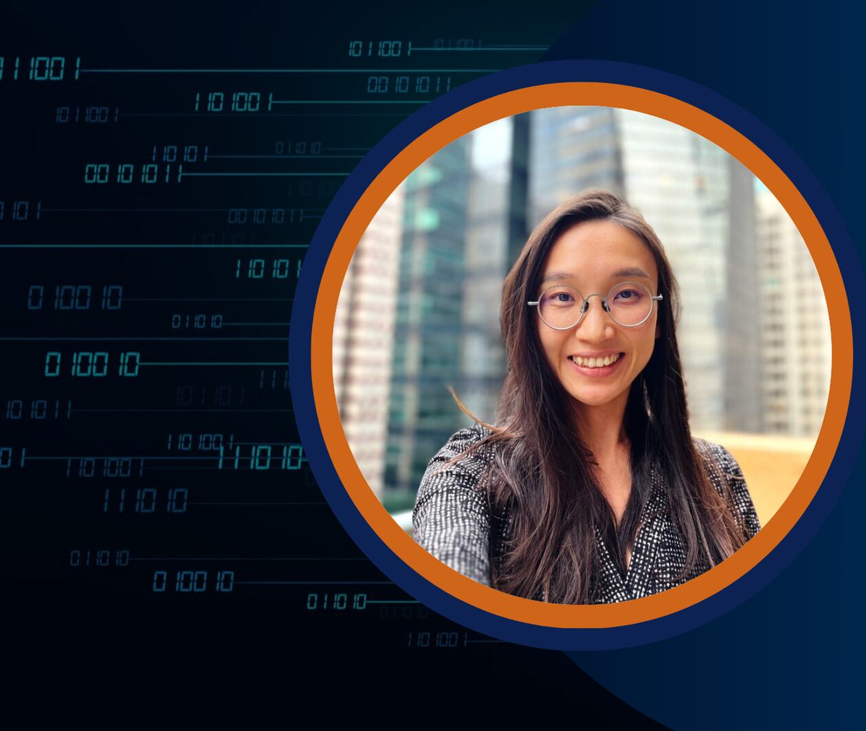 A professional woman with long dark hair and glasses smiles at the camera, with tall city buildings in the blurred background. She is framed in a circular border with an orange and navy blue ring.