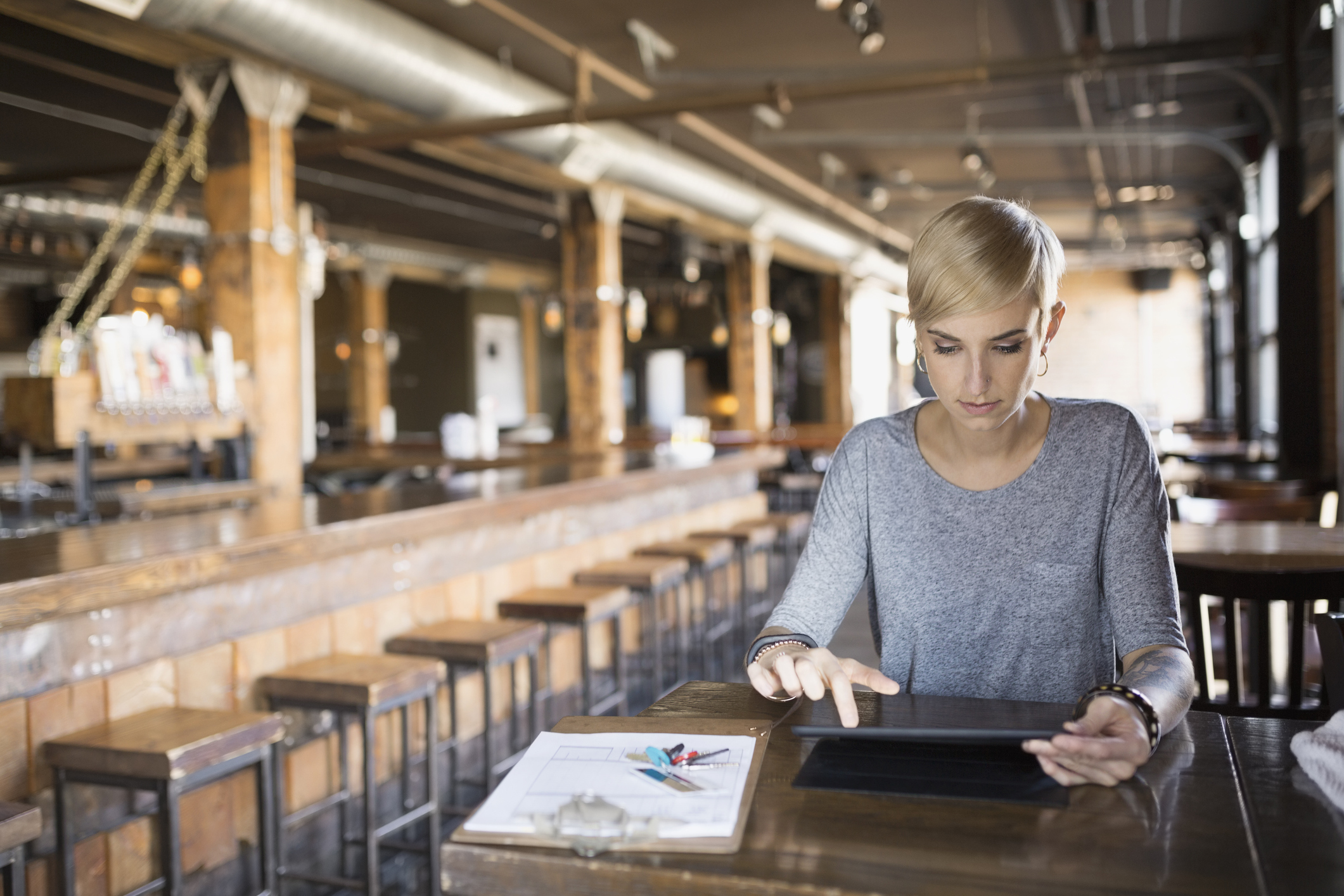 Woman deciphering figures in industrial restaurant venue