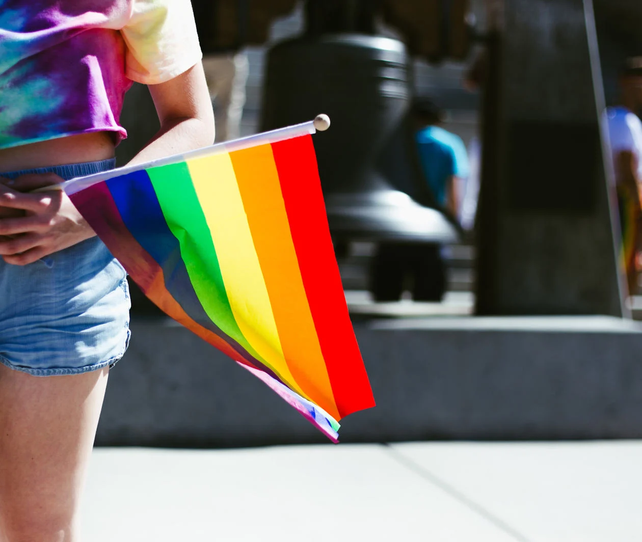 Person holding a rainbow flag