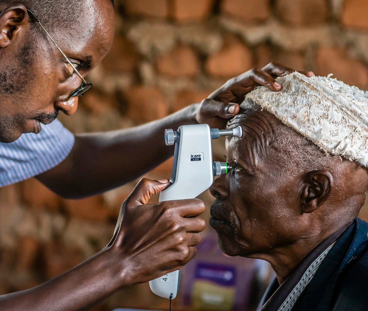 A male physician examining a elderly males eyes, to see if there are any signs or symptoms of glaucoma