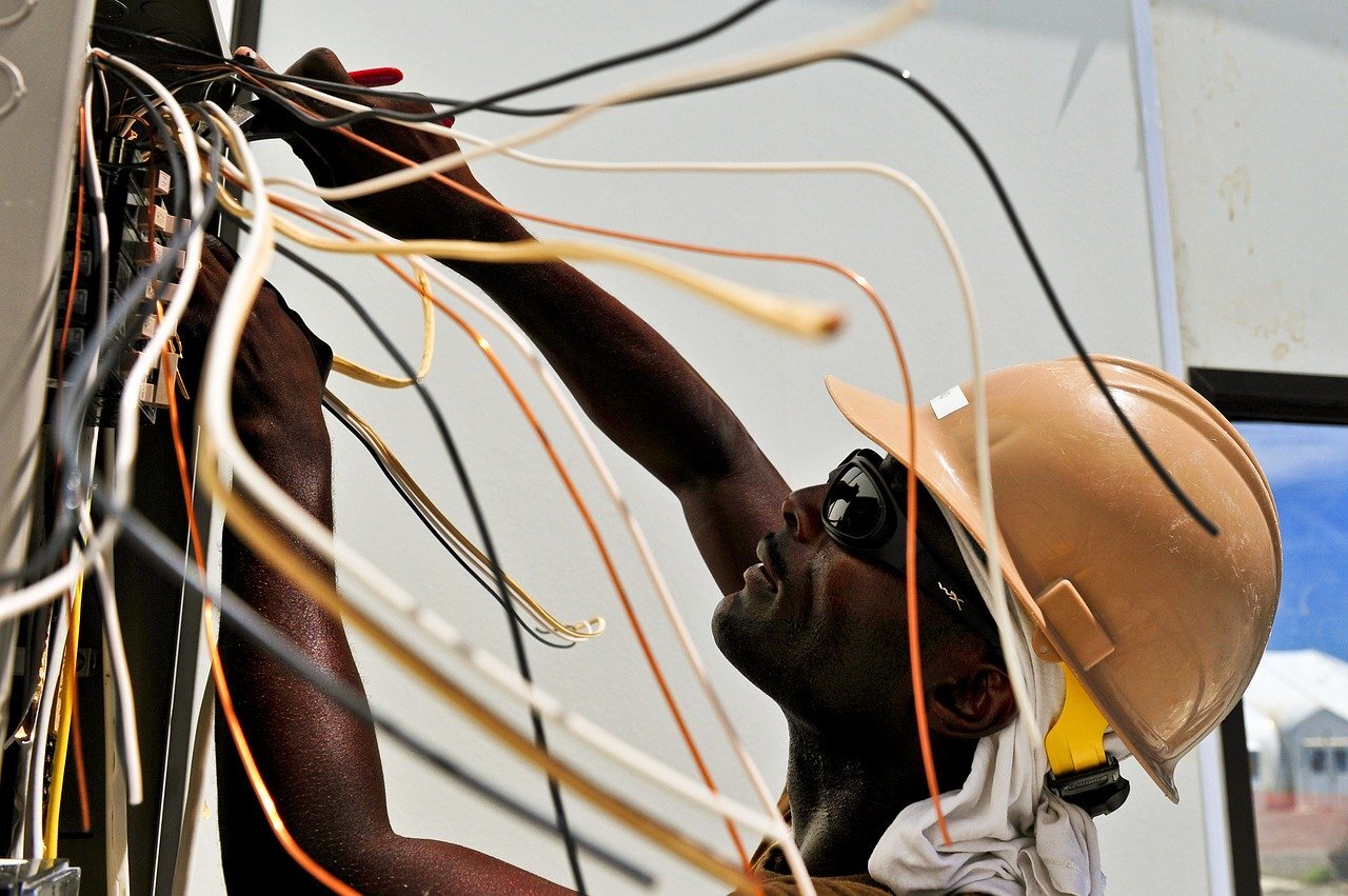 A technician looking carefully a a complex network of wires they are working on