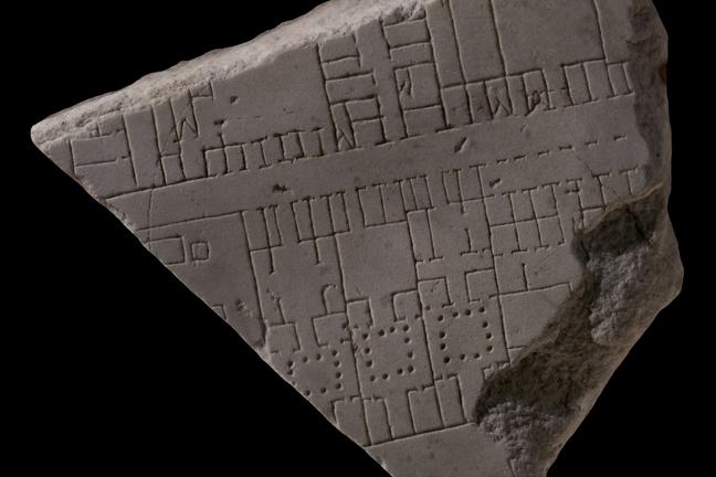A marble tablet with carvings etched on that consists of lines