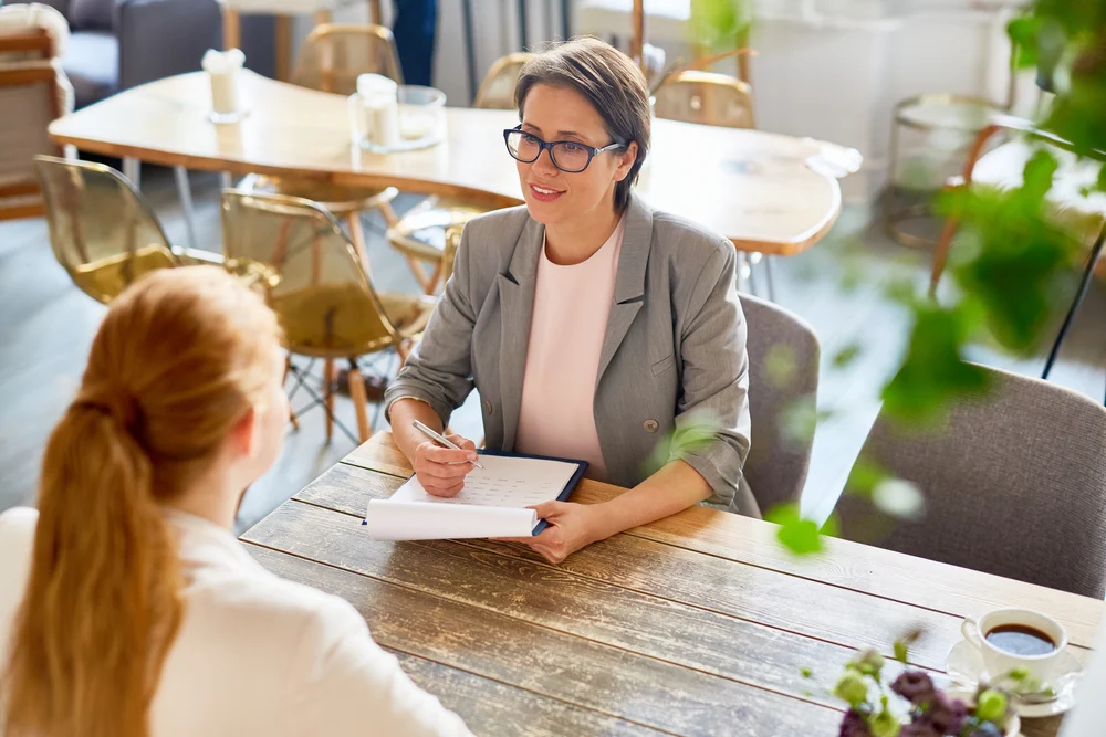 Two women sit at the table in an informal interview situation.