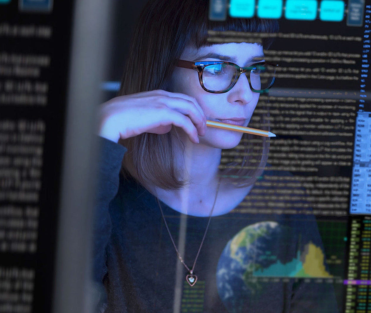 A woman looking at a screen with information on it