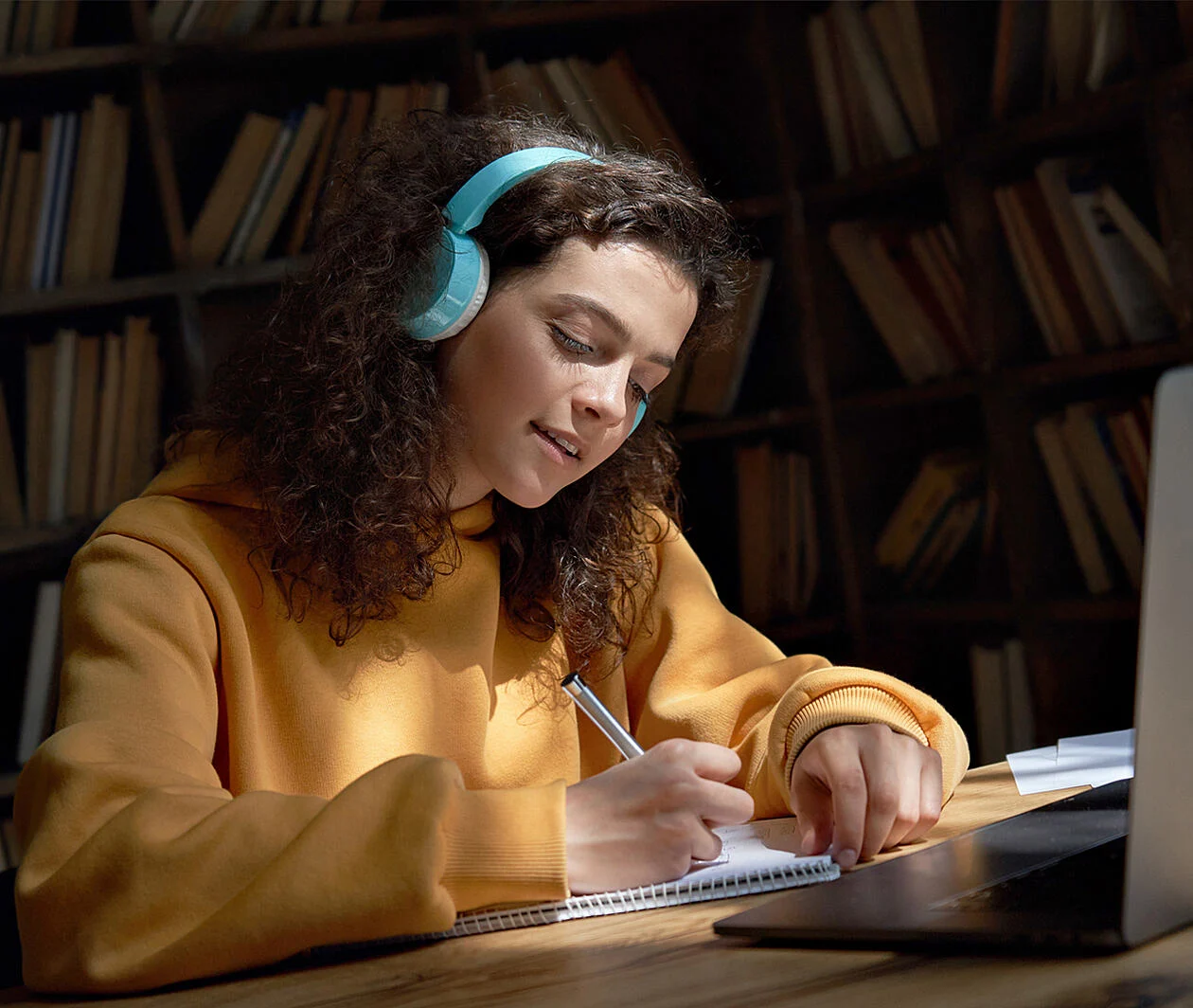 Woman sat in front of laptop making notes