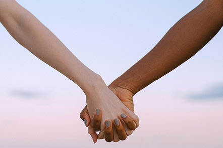 two people holding hands only arms are visible in a v shape