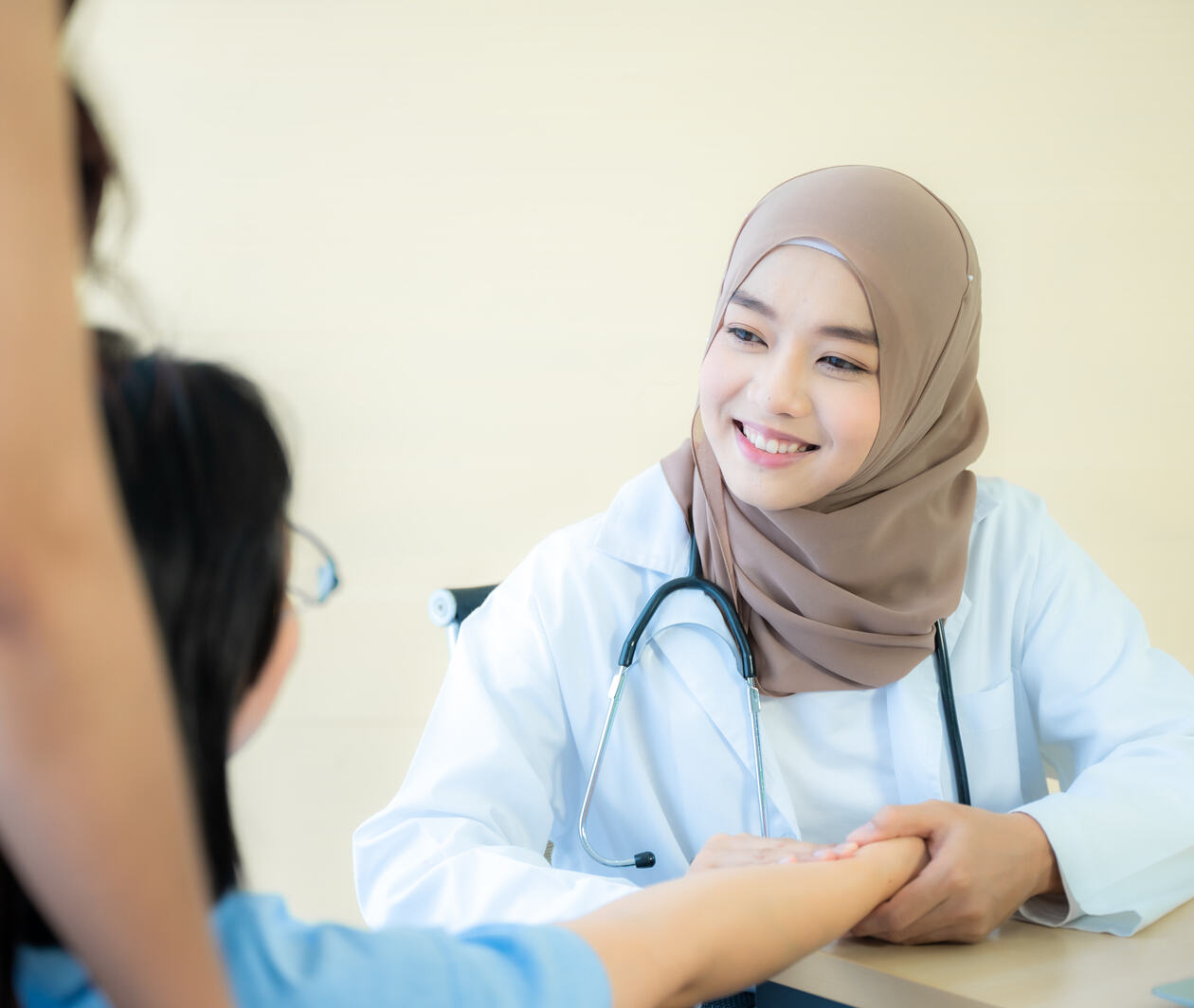 The beautiful Muslim doctor wear hijab works at the hospital to take care the elderly patient. The concept of aging society under the COVID-19 pandemic situation.