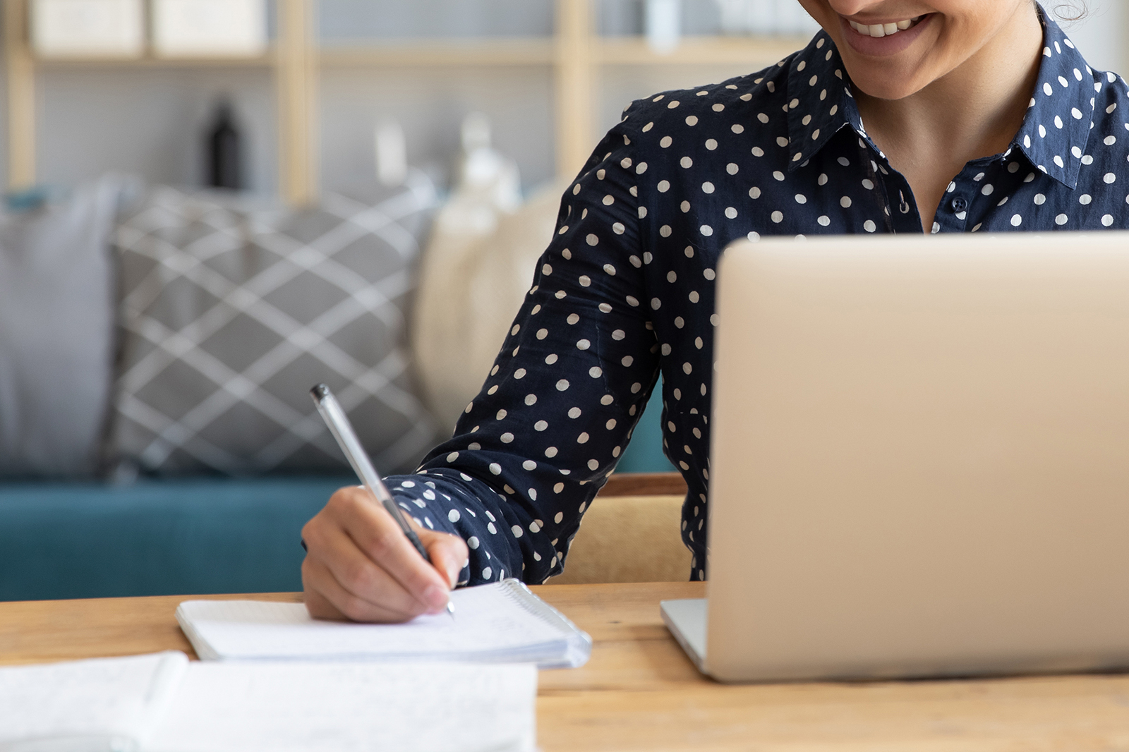 Woman writing into a notepad at a desk