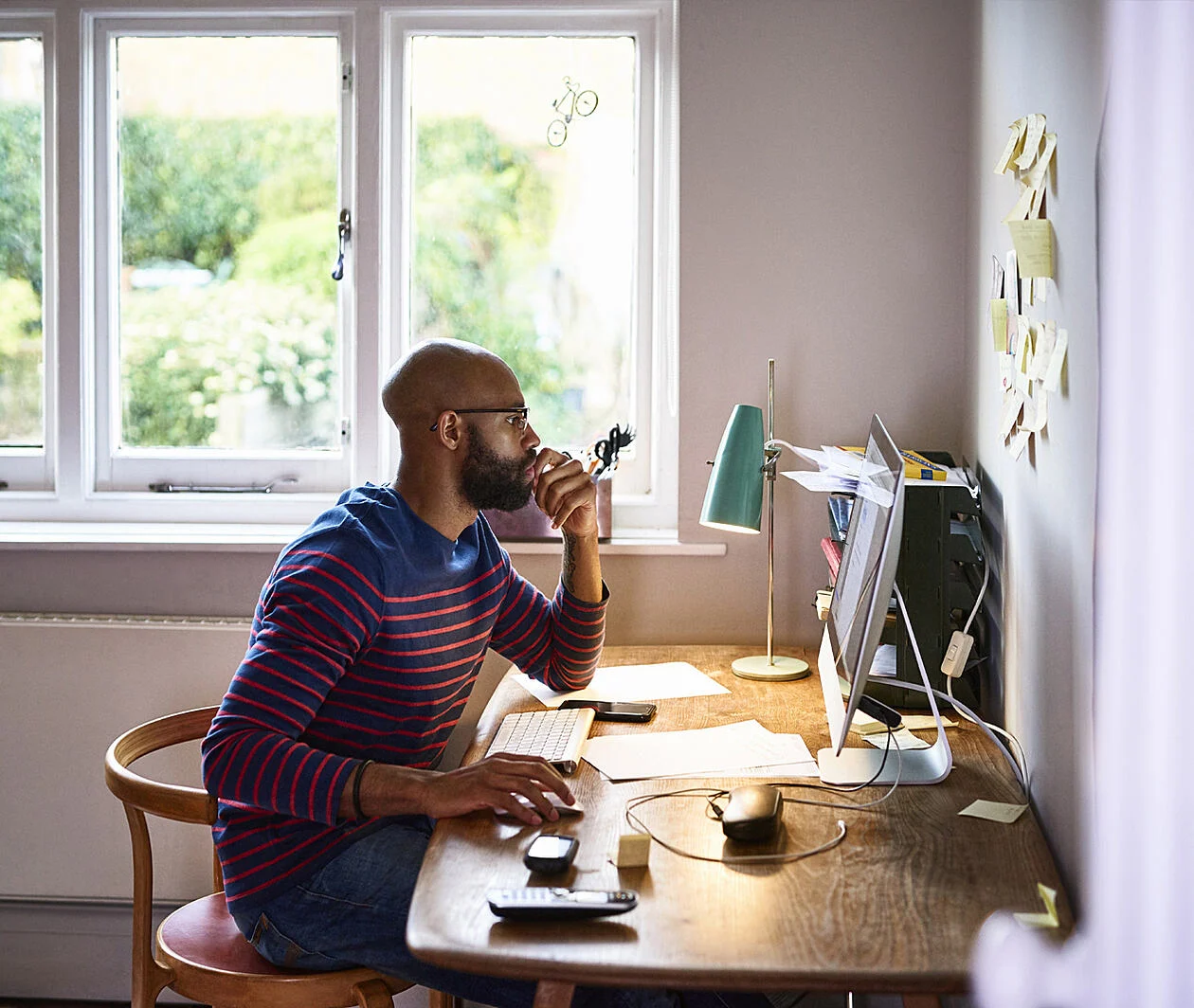 Man sat at a desk working on a computer.