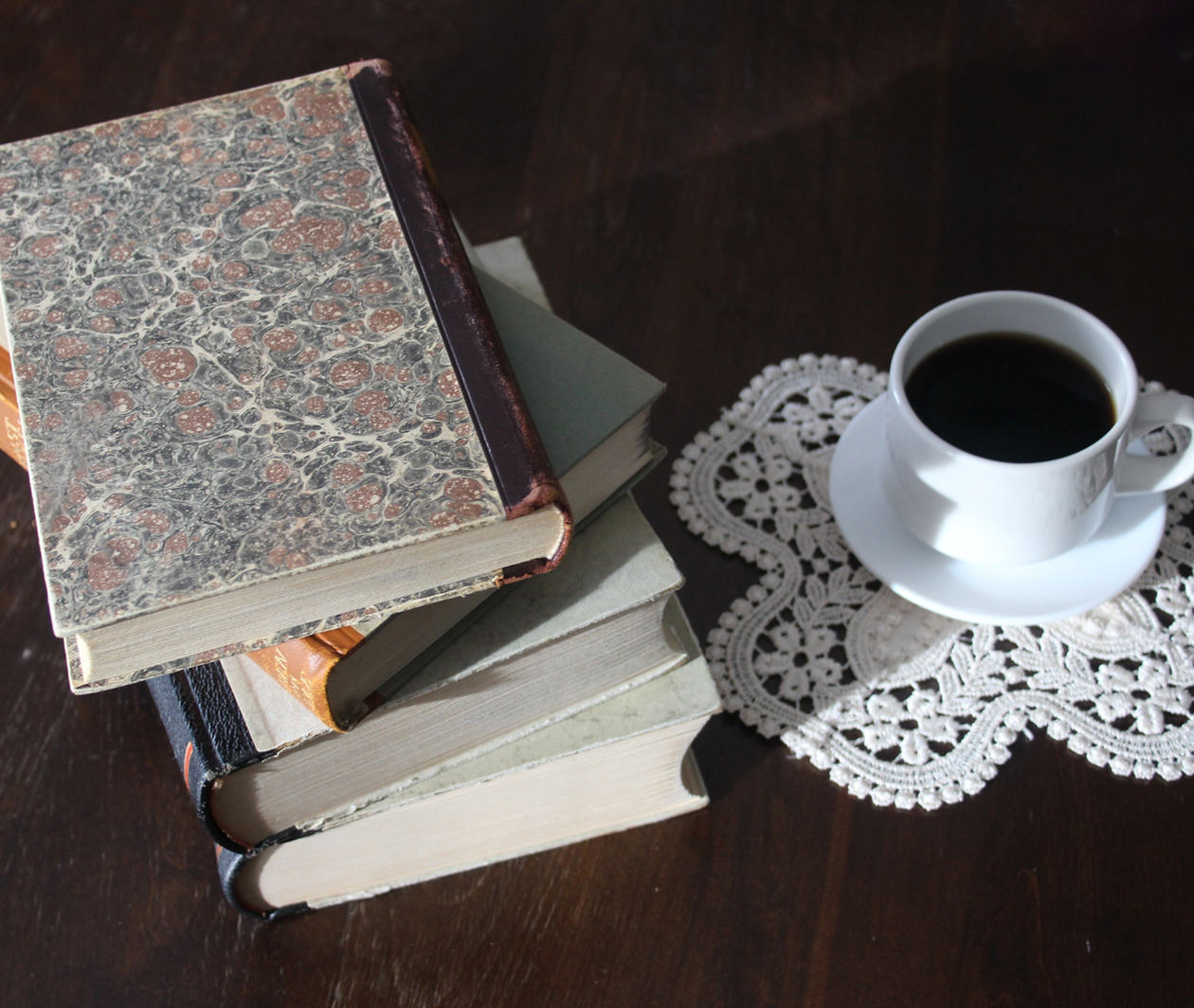 Books set down on table with tea cup