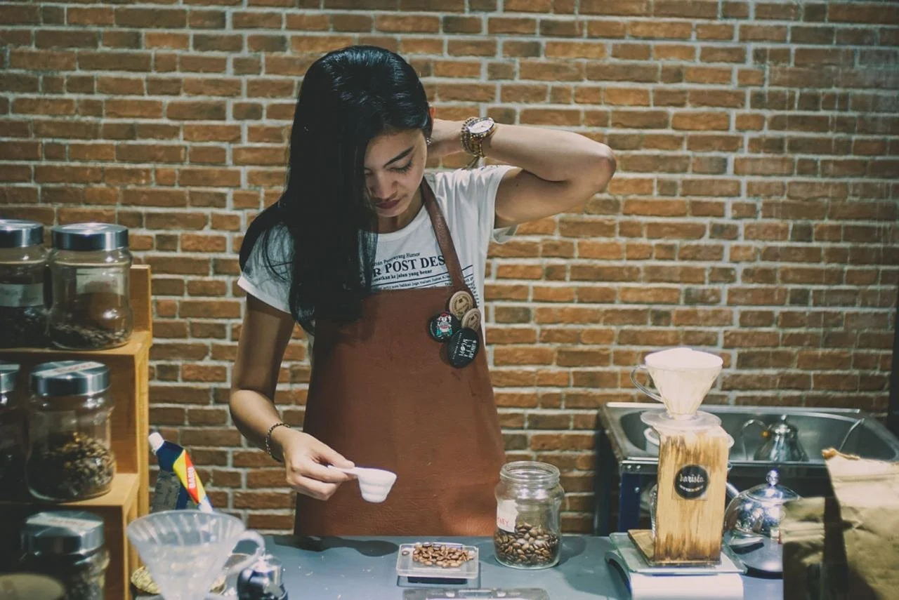 Young woman working at the counter in a coffee shop