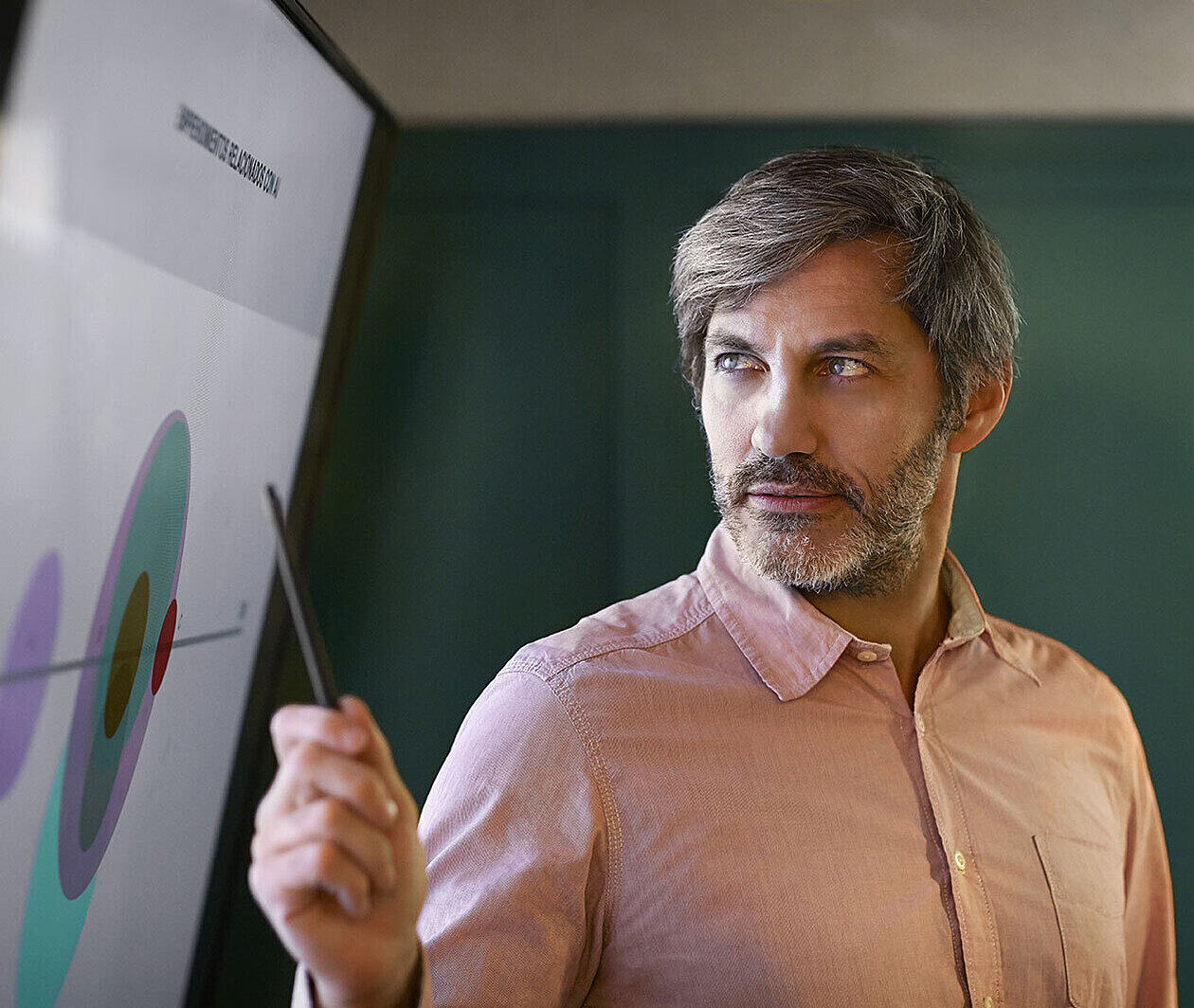 Man pointing at a chart on a big screen.