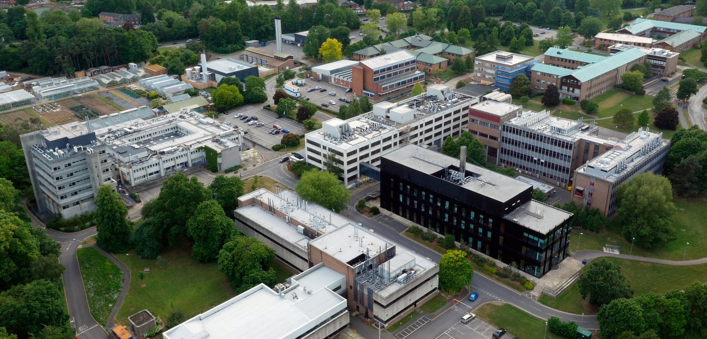 Birds-eye view of University of Reading campus showing buildings surrounded by trees and green spaces.