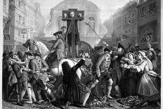 Daniel Defoe being held in a pillory while soldiers have to restrain crowds from throwing flowers at him