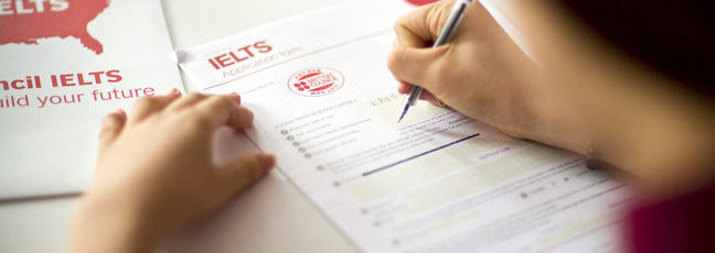 Somebody completing an IELTS application form
